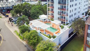 Un hôtel à plusieurs étages doté d’une piscine sur le toit et d’un espace extérieur aménagé pour se détendre.