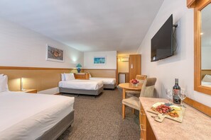 Relax in this stylish room with two single beds, a flat-screen TV, and a small table with a fruit platter.