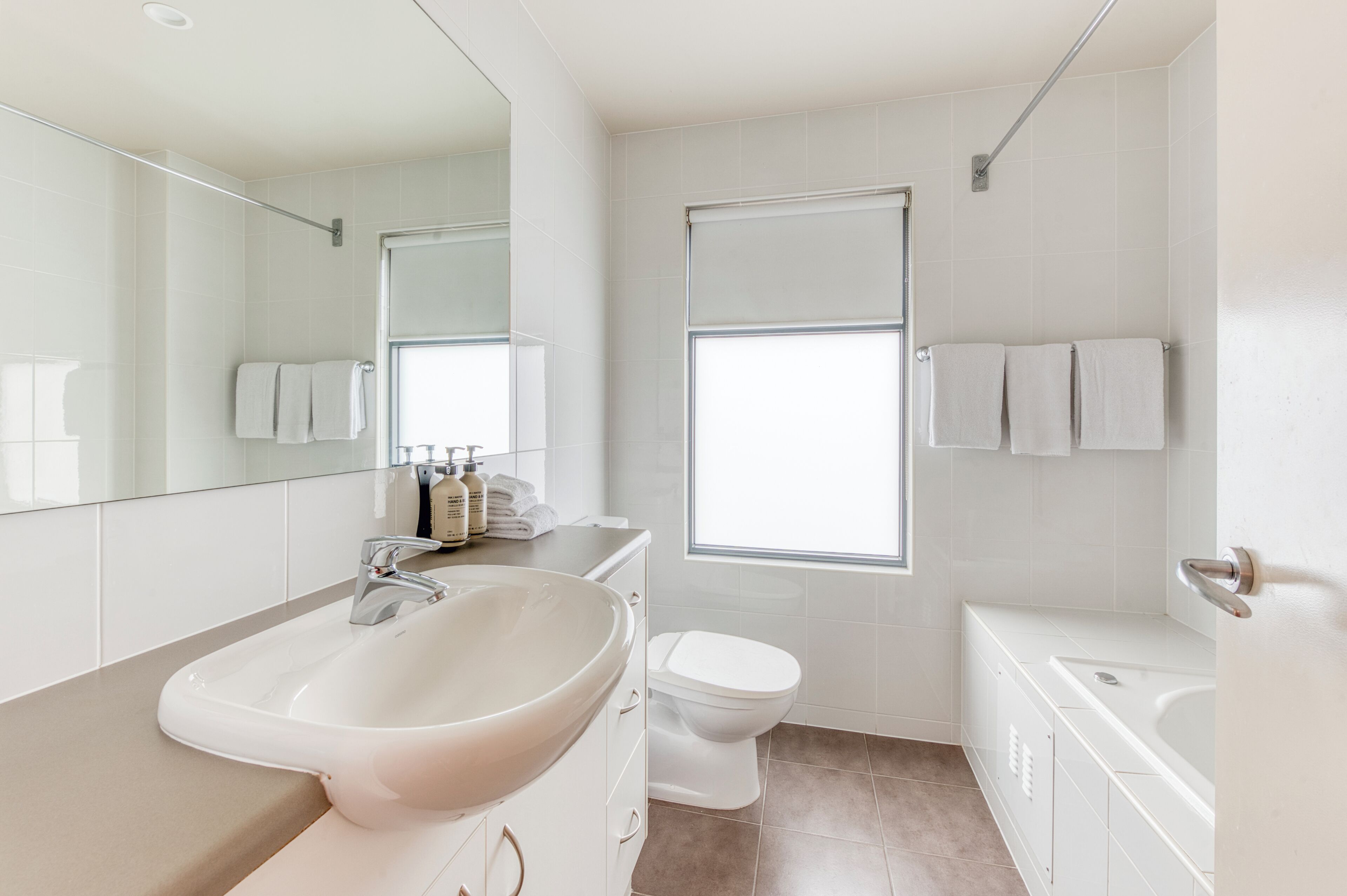 A modern bathroom with a large sink, toilet, and bathtub.