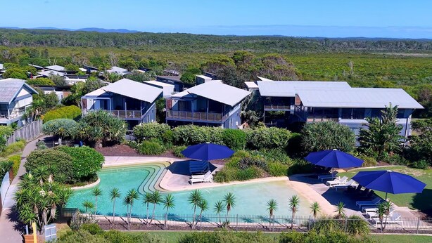 A resort with multiple modern villas, a central swimming pool, and lush greenery. - Serenity Diamond Beach (Diamond Beach)