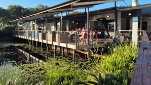 A riverside restaurant with outdoor seating overlooking a pond. - Serenity Diamond Beach (Diamond Beach)