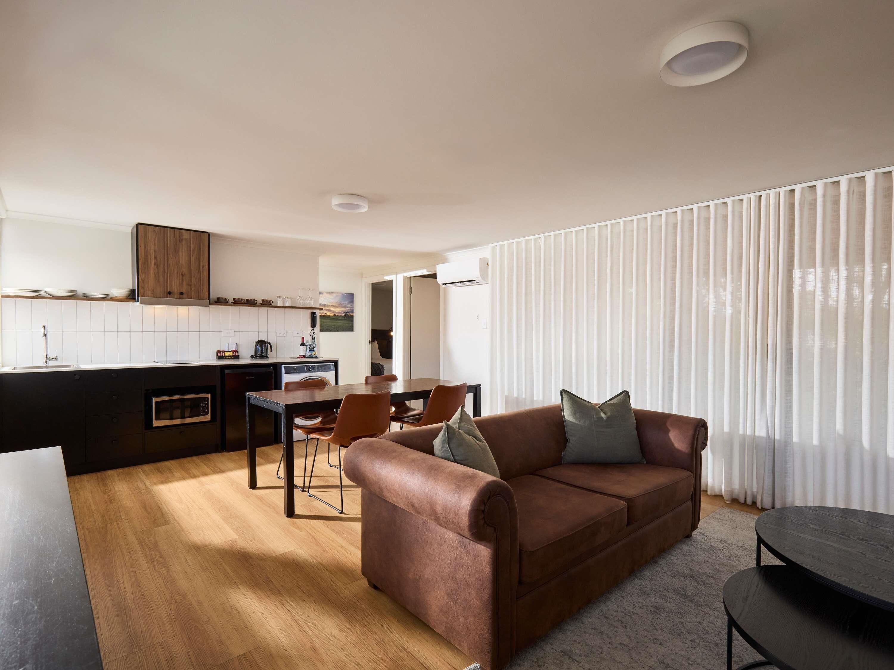 A modern living space with a kitchen, dining area, and a sofa.