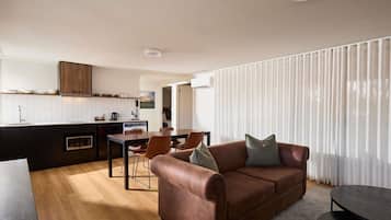 A modern living space with a kitchen, dining area, and a sofa.