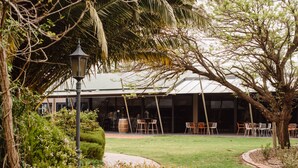 A building with a covered outdoor seating area, surrounded by greenery and a lamp post. - Mercure Barossa Valley (Tanunda)