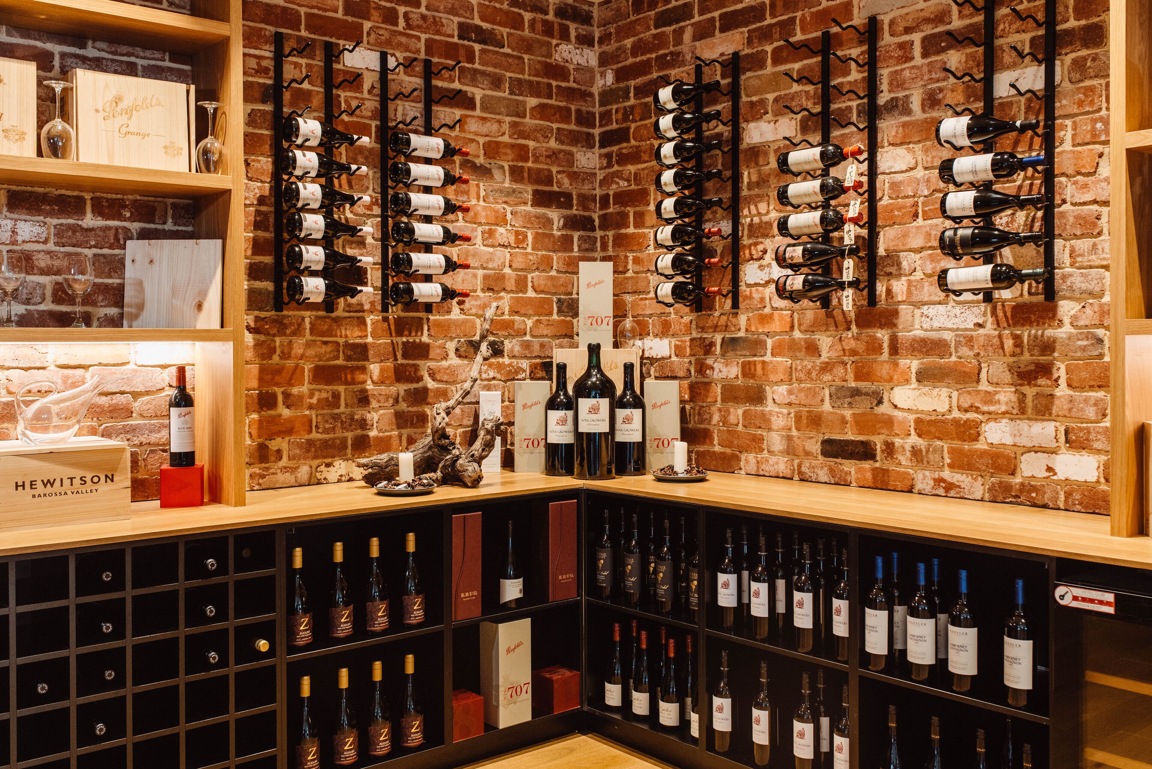 Une cave à vin avec des étagères et des supports en bois pour ranger les bouteilles de vin.