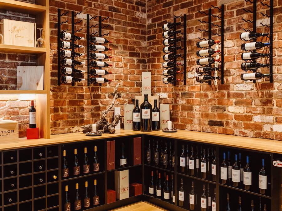 Una celler de vi amb prestatges i bastidors de fusta plens de garrafes.