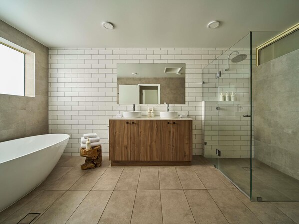 Une salle de bain moderne avec une baignoire sur pieds, un meuble-lavabo en bois avec un miroir et une cabine de douche en verre.
