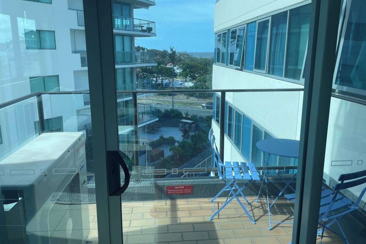 A balcony with a view of a parking area and buildings.