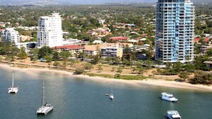 A coastal cityscape with high-rise buildings, a sandy beach, and several boats on the water. - Blue Waters Apartments (Labrador)