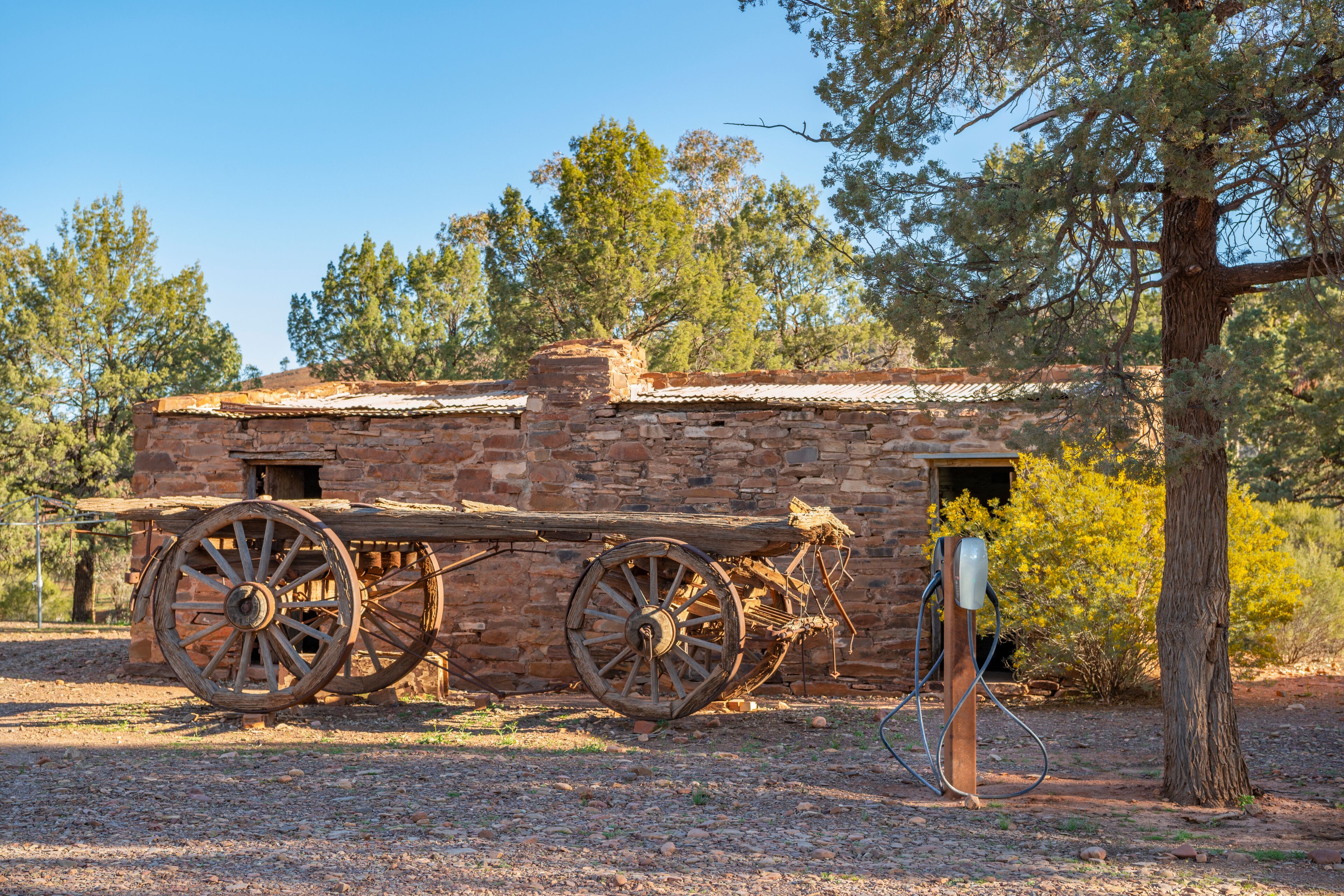 Un bâtiment rustique en pierre, agrémenté de grandes roues en bois fixées sur le côté, ce qui laisse supposer qu’il a une importance historique.