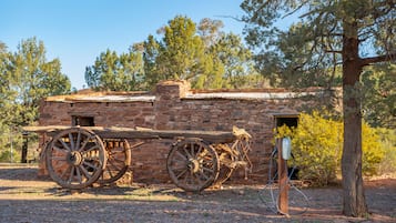 Un bâtiment rustique en pierre, agrémenté de grandes roues en bois fixées sur le côté, ce qui laisse supposer qu’il a une importance historique.