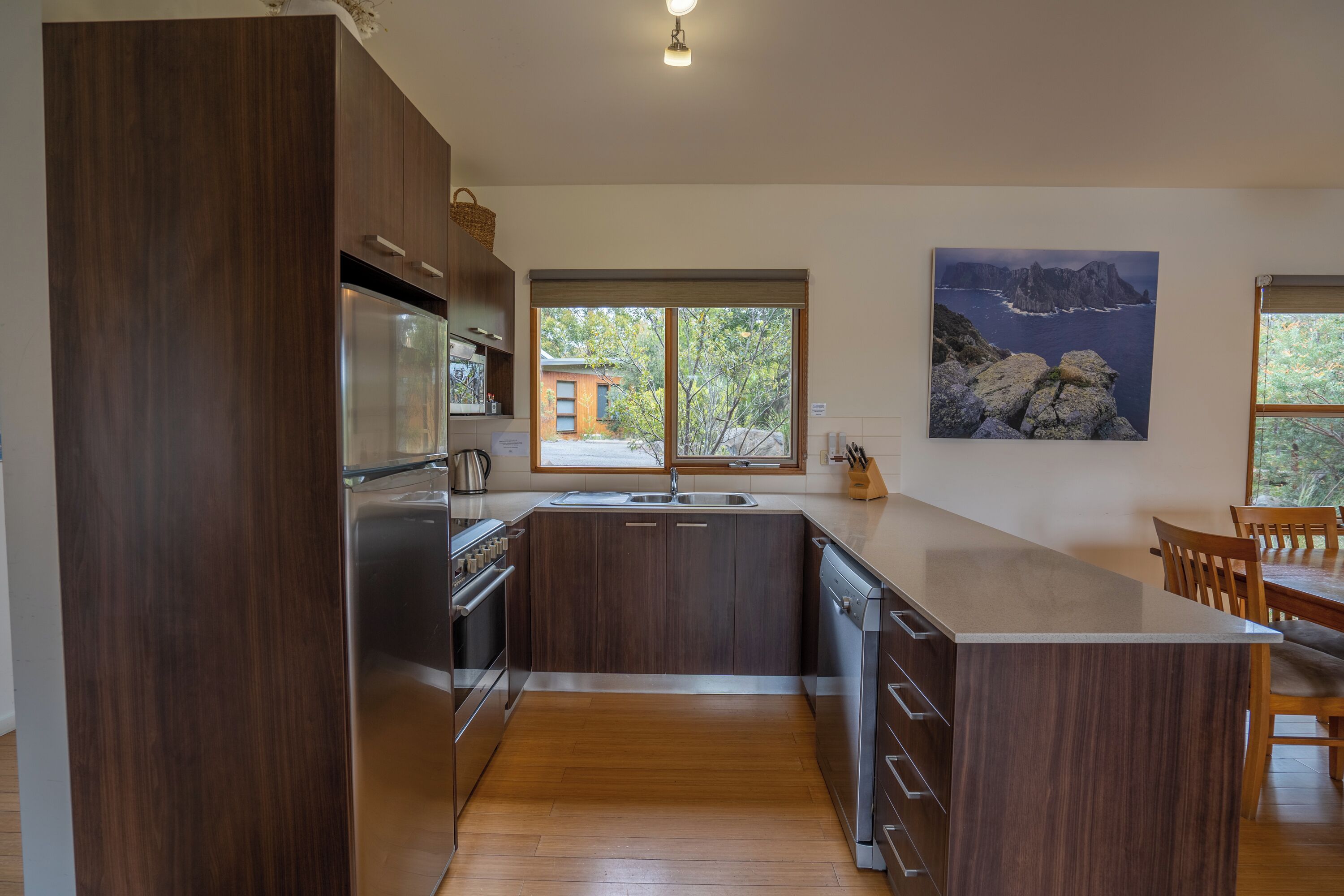 Una cocina moderna con armarios de madera oscura, electrodomésticos de acero inoxidable y una isla grande.
