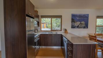 Una cocina moderna con armarios de madera oscura, electrodomésticos de acero inoxidable y una isla grande.