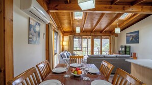 A wooden dining table set with plates, glasses, and a bowl of fruit. - Stewarts Bay Lodge (Port Arthur)