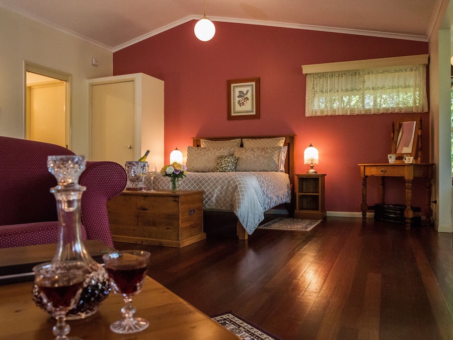 Un dormitorio acogedor con una cama, cómoda de madera y mesita de noche con lámpara.