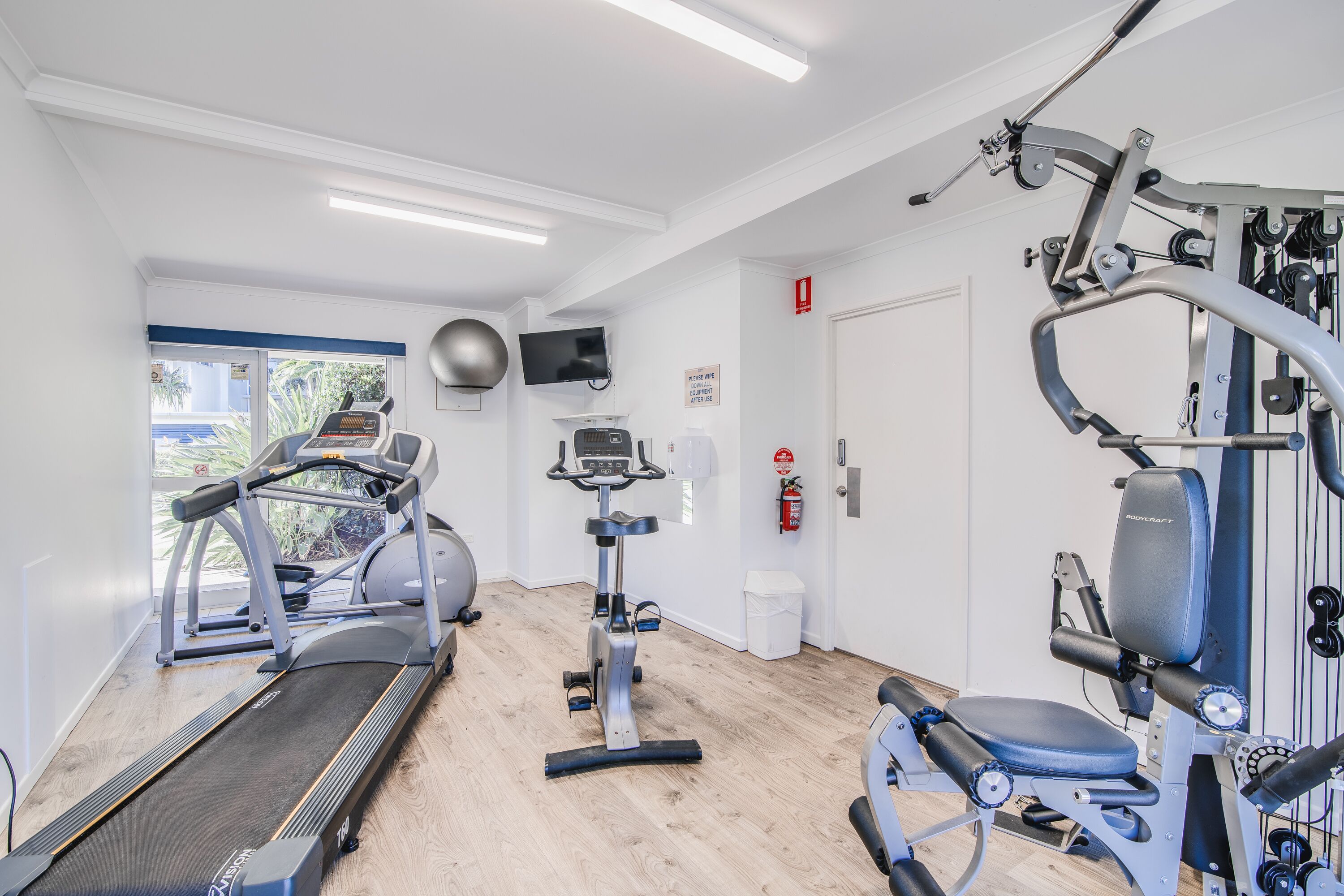 A gym with treadmills, an elliptical, and weight machines.