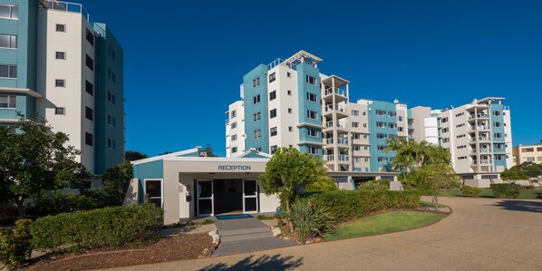 A modern hotel with a reception area, multiple floors, and a landscaped entrance.