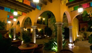 An indoor courtyard with arches, columns, and potted plants. - Antigua Capilla B&B (San Miguel de Allende)