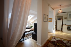 A modern kitchen with a microwave, refrigerator, and wooden cabinets.