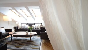 A modern living room with a sofa set, a coffee table, and a lamp. - Crystal Suites Old Town (Kraków)