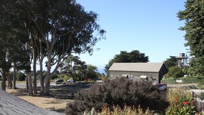A building with a sloped roof, surrounded by trees and shrubs. - Seagull Inn (Mendocino)