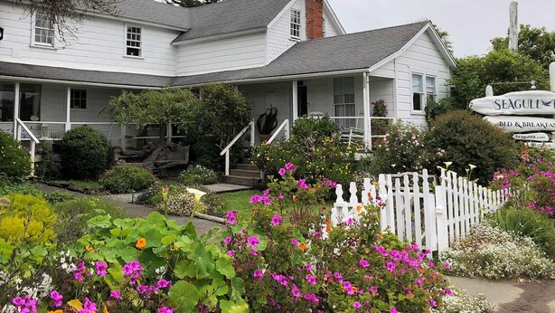 A white building with a porch and a sign reading "Seagull Inn." - Seagull Inn (Mendocino)