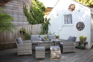 Relax on the patio with a sofa, two ottomans, and a coffee table.