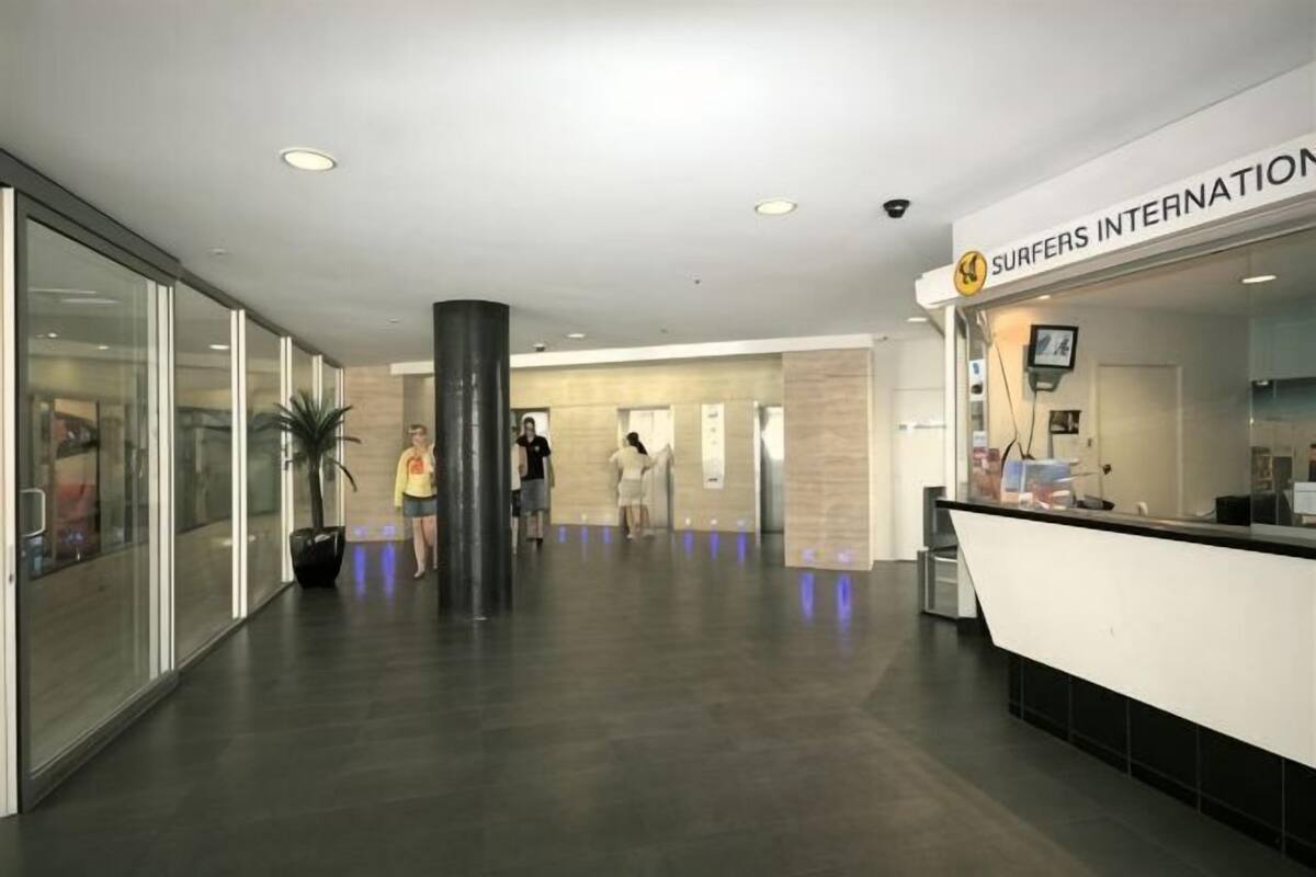 A modern reception area with a reception desk, glass walls, and a large pillar.