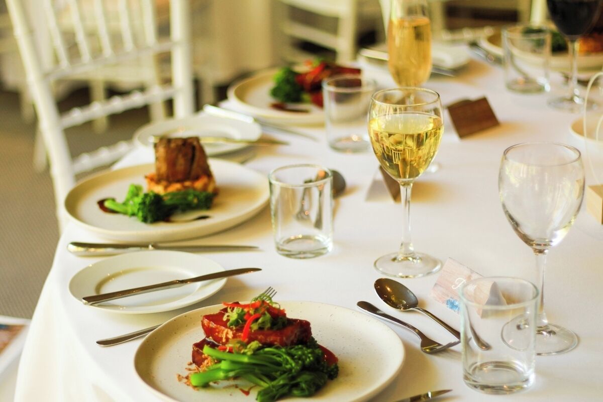 A dining table set with plates, cutlery, and glasses, suggesting a restaurant setting.