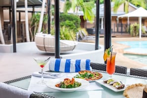 Enjoy a meal al fresco with a view of the pool and lush surroundings.