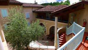 A courtyard with a staircase, a tree, and a building with a tiled roof. - VVF Gers Gascogne, Mauvezin (Mauvezin)