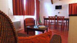 A living room with a sofa, a coffee table, and a dining area with chairs and a table. - VVF Gers Gascogne, Mauvezin (Mauvezin)