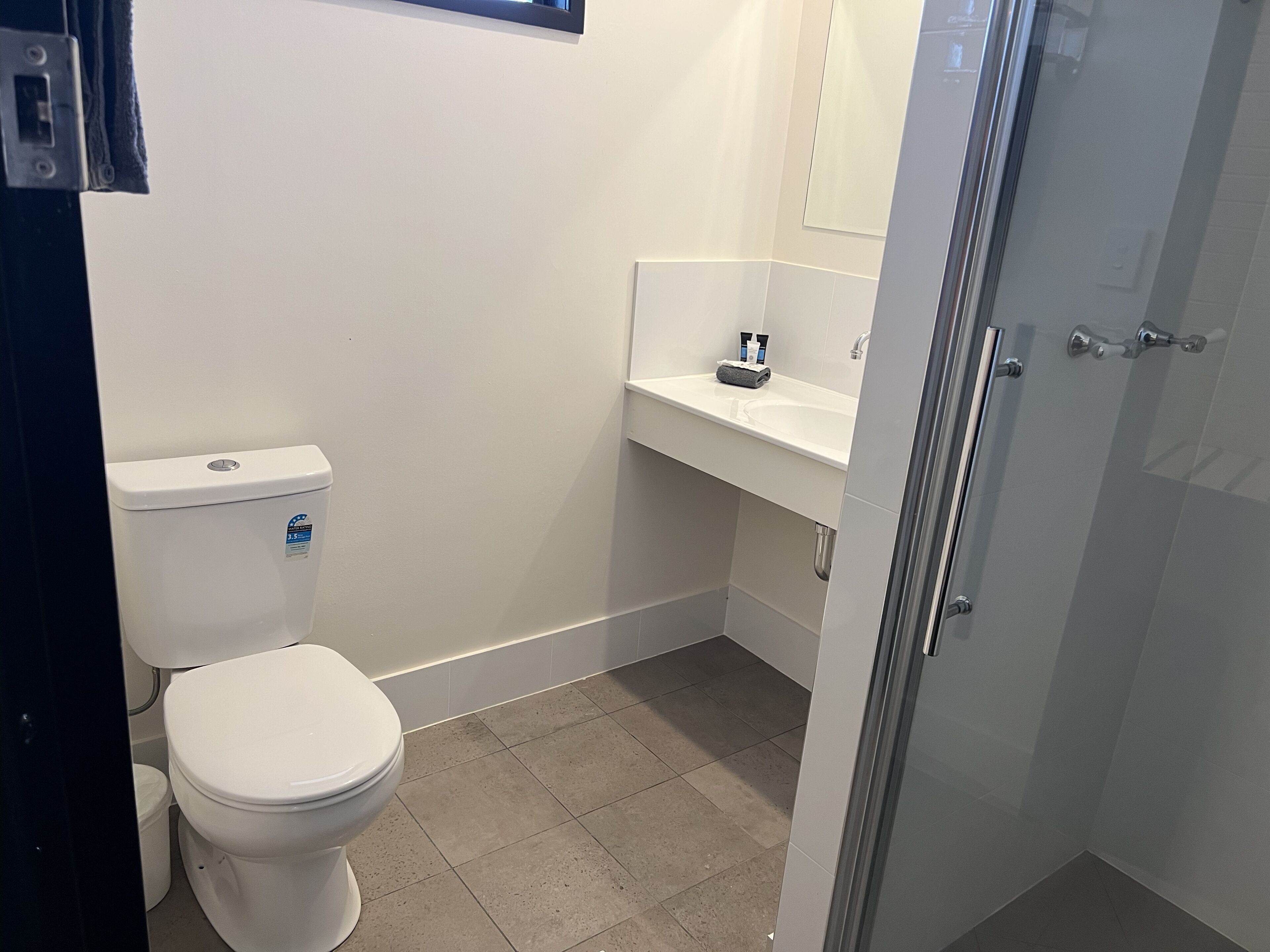 Ein Badezimmer mit Toilette, Waschbecken und Duschbereich.