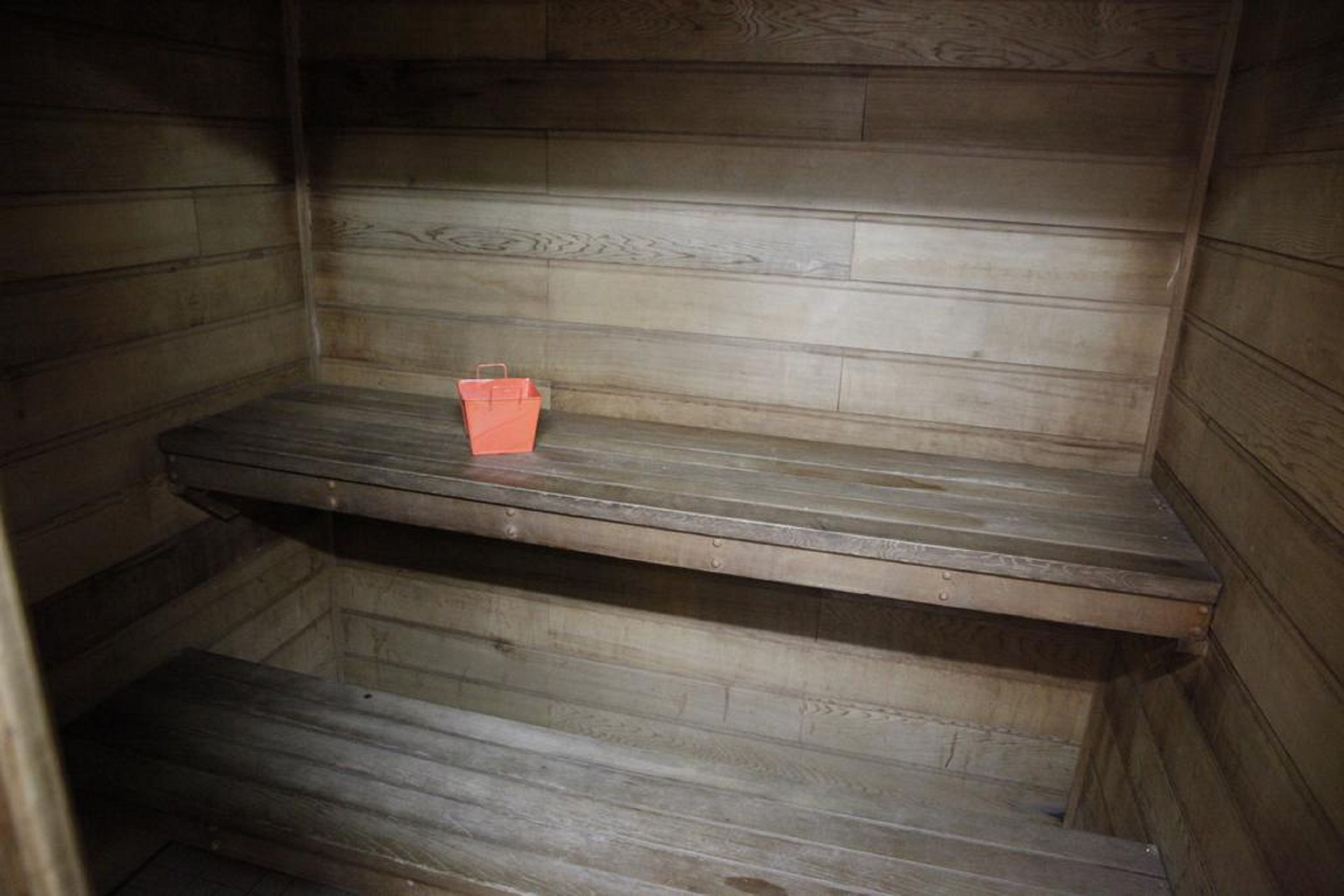 A wooden interior with a single shelf and a red object on it.