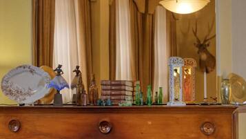 A wooden dresser with various decorative items including glass bottles, a plate, and figurines.