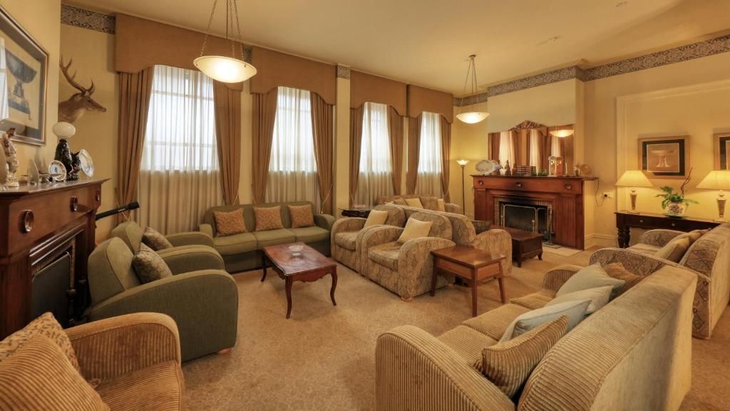 A traditional living room with a fireplace, multiple sofas, and a coffee table.