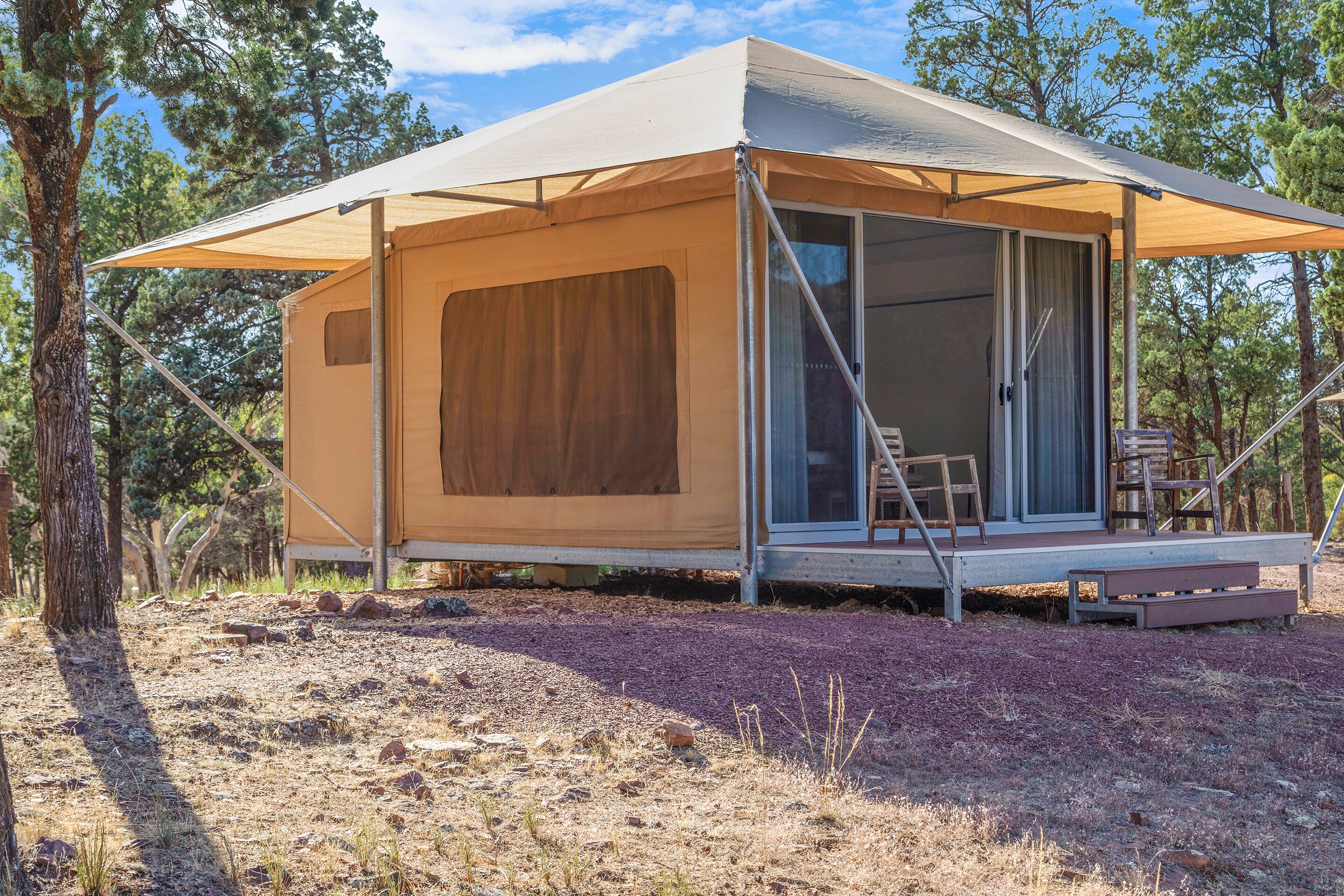 A single-story, A-frame tent with a sliding door and a small porch area.