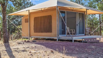 A single-story, A-frame tent with a sliding door and a small porch area.