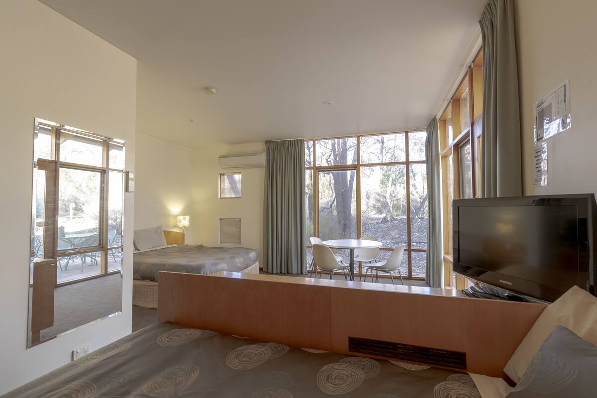 Cortinas blackout, tabla de planchar con plancha y ropa de cama