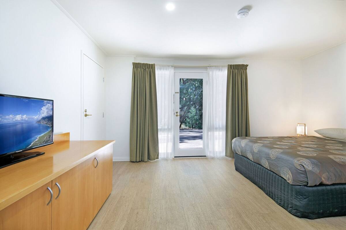 Cortinas blackout, tabla de planchar con plancha y ropa de cama