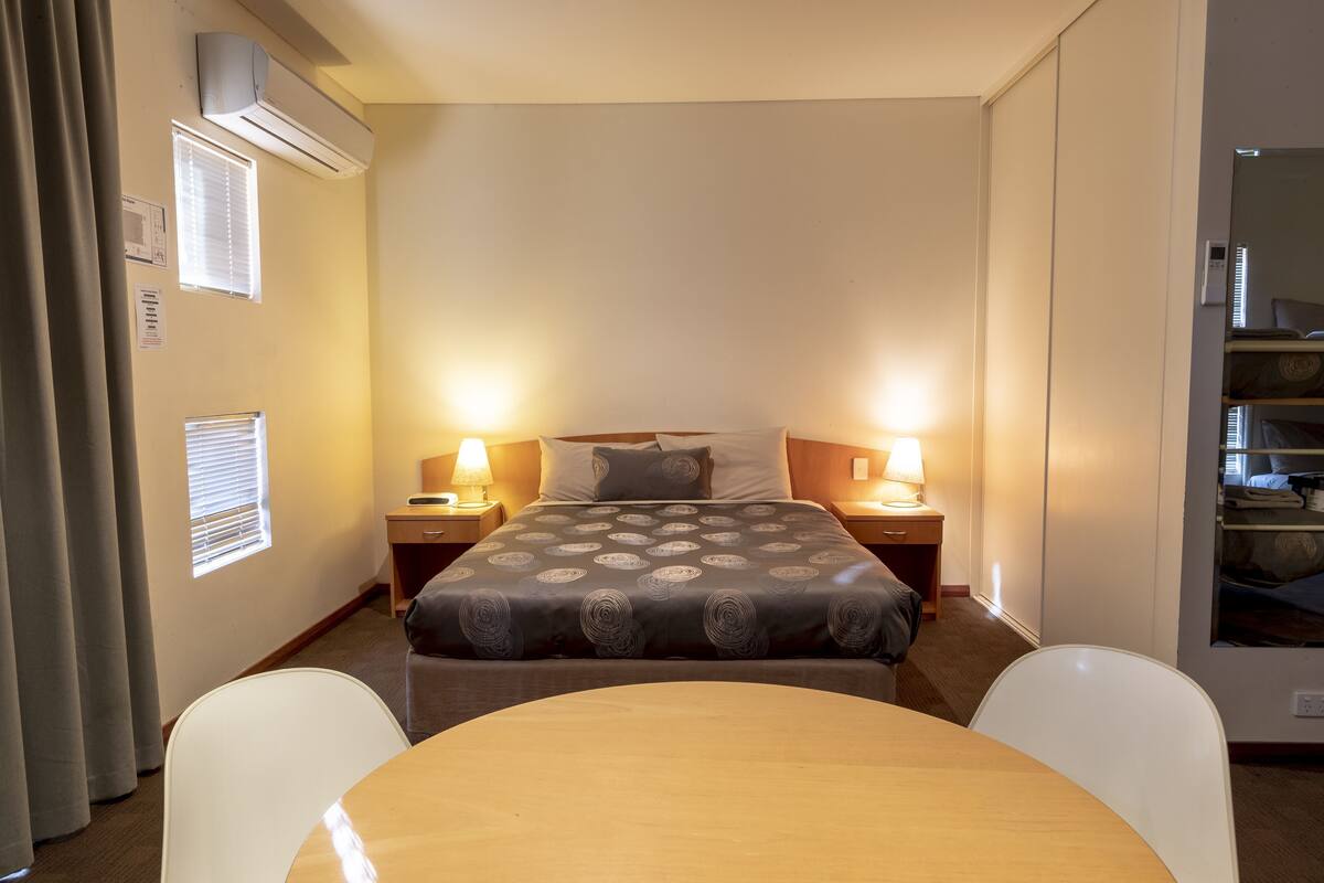 Cortinas blackout, tabla de planchar con plancha y ropa de cama