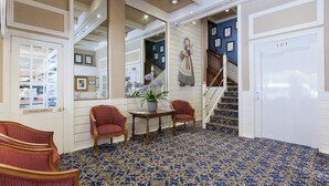 A hallway with a blue patterned carpet, a staircase, and a sign labeled 'LIFT'. - European Hotel (Perth)
