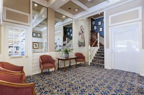 A hallway with a blue patterned carpet, a staircase, and a sign labeled 'LIFT'. - European Hotel (Perth)