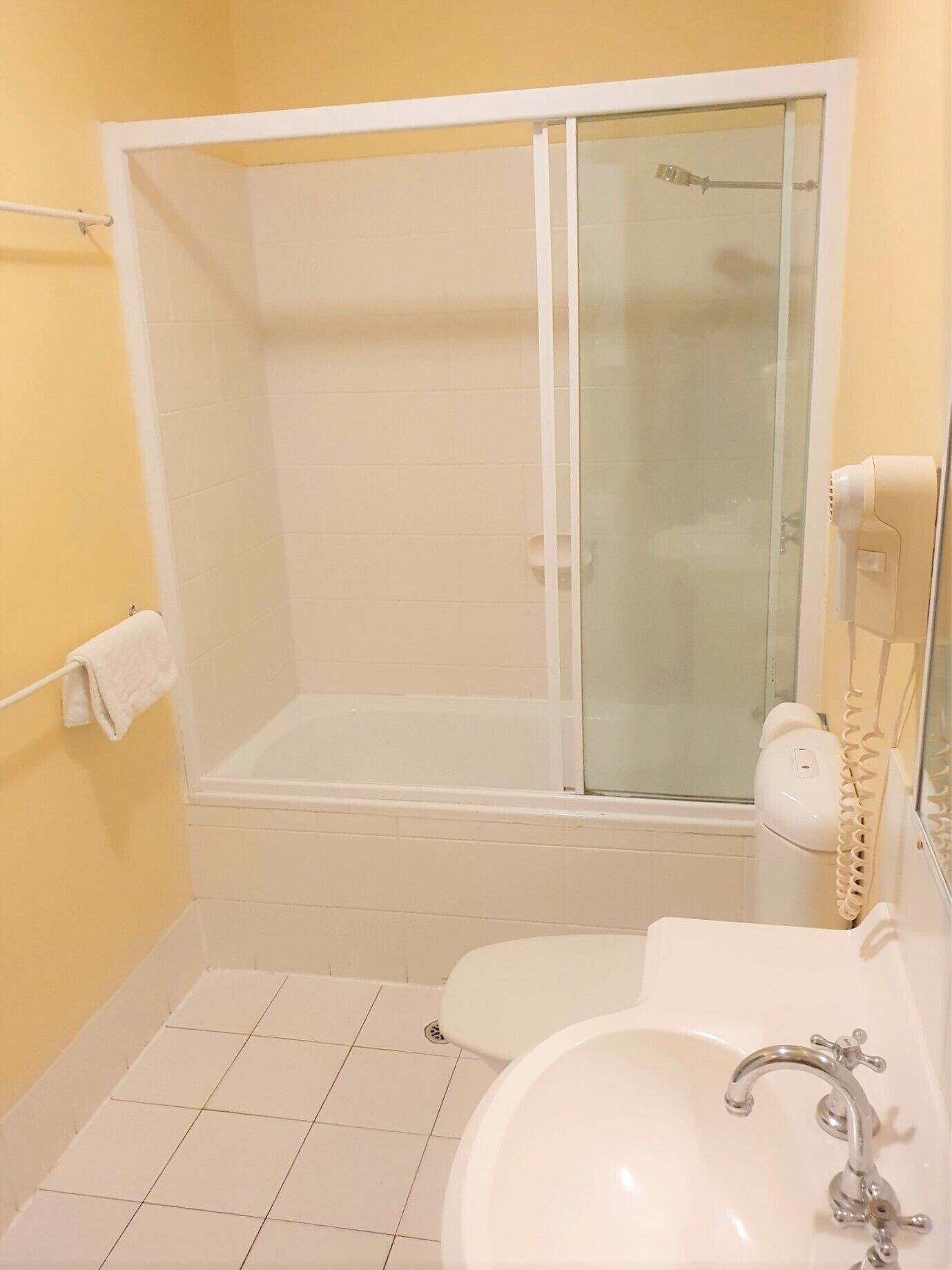 A bathroom with a bathtub, a shower enclosure, a toilet, and a sink.