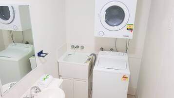 Una lavandería con lavadora, secadora y lavabo.