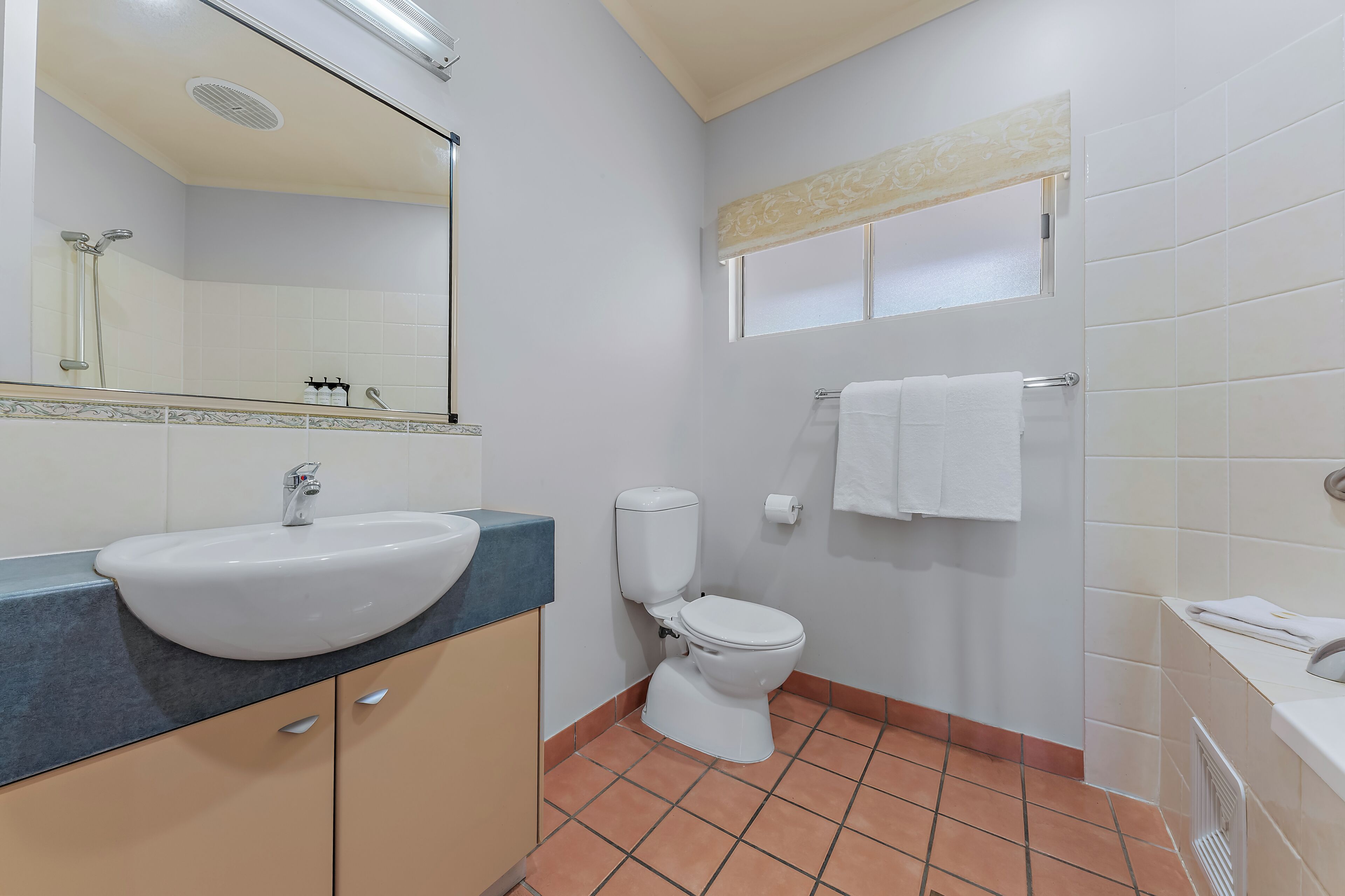 A bathroom with a sink, toilet, and shower.