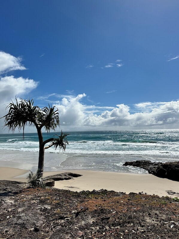 Una playa cerca, arena blanca, camas de playa
