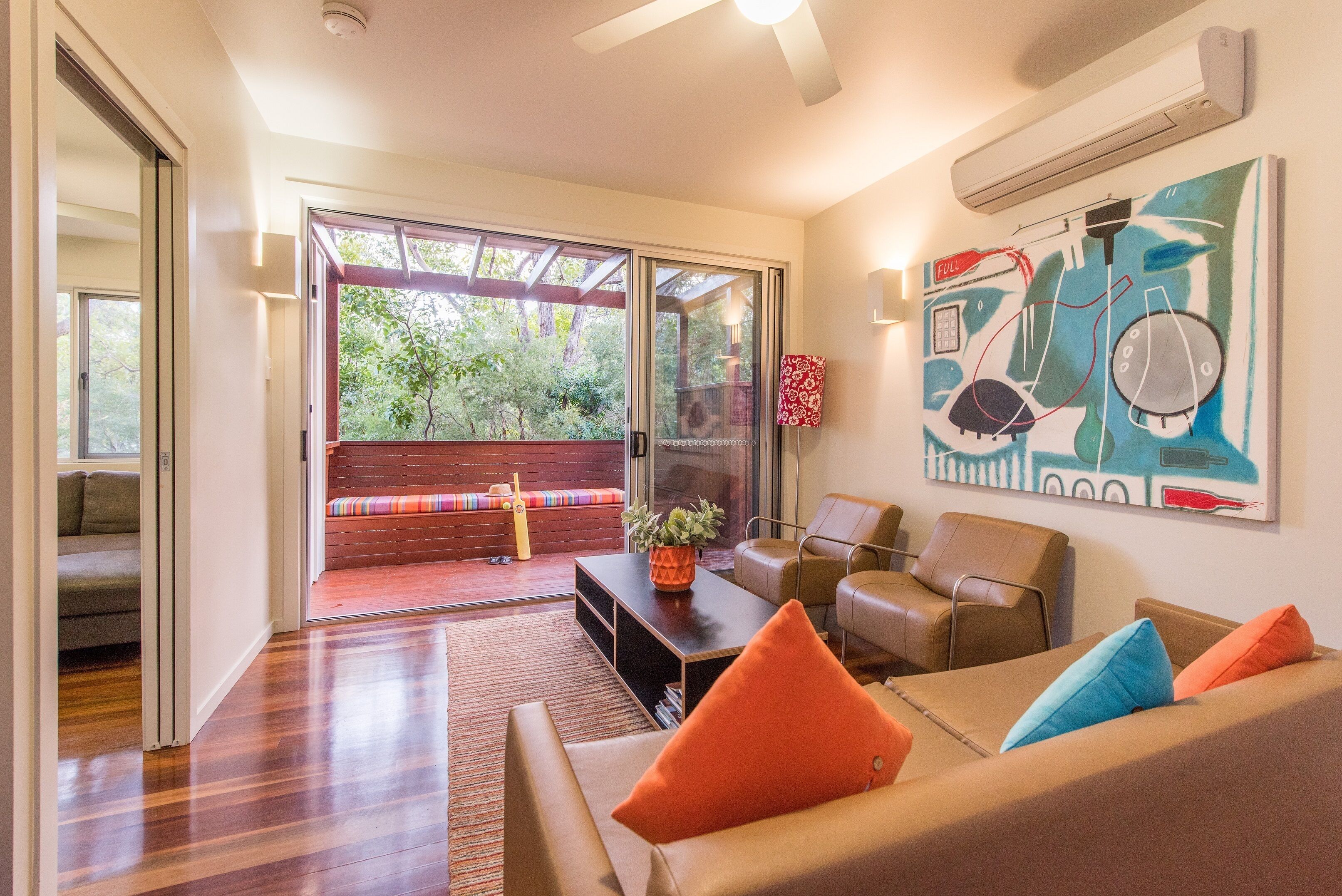 A modern living room with a sofa, armchairs, a coffee table, and a large window.