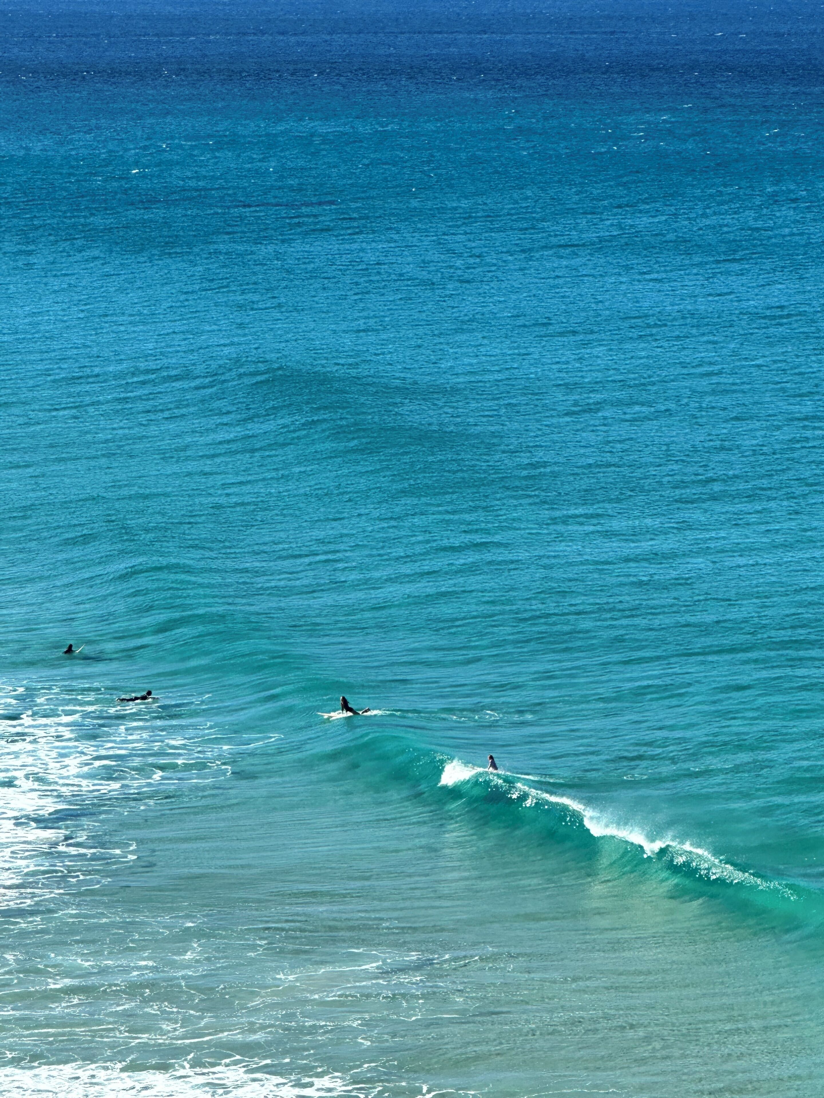 Une vue sur l’océan, avec des vagues et un surfeur.