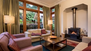 A cozy living room with a sofa, armchairs, a coffee table, and a fireplace. - Franklin Manor (Strahan)